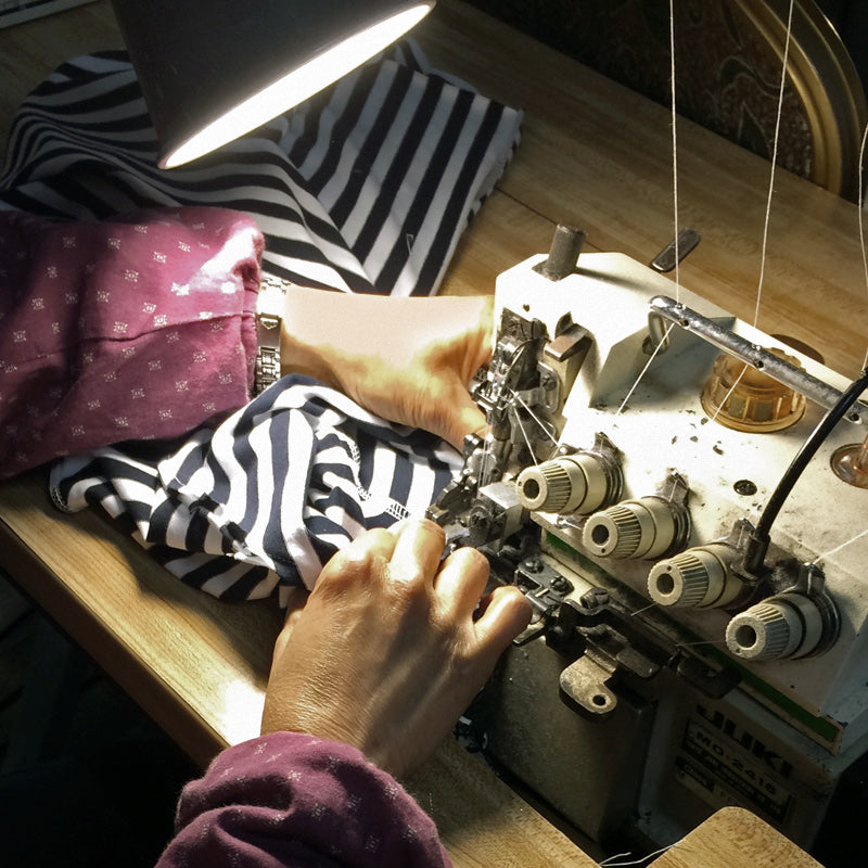 Artisan sewing Lacson Ravello striped garment at Oakland sustainable clothing factory